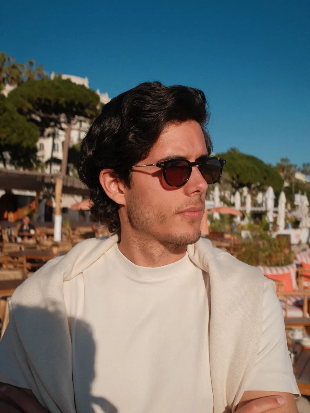 Portrait of Alex Klaric, Mexican-American entrepreneur, in sunglasses on a beach terrace in Cannes, France