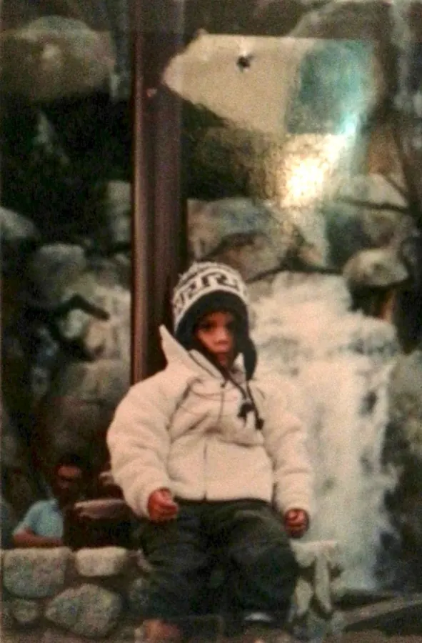Alex Klaric as a toddler in Guadalajara, Mexico, wearing a white winter coat